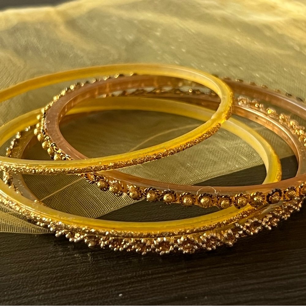 4 goldtone beaded plastic bangles + yellow travel pouch